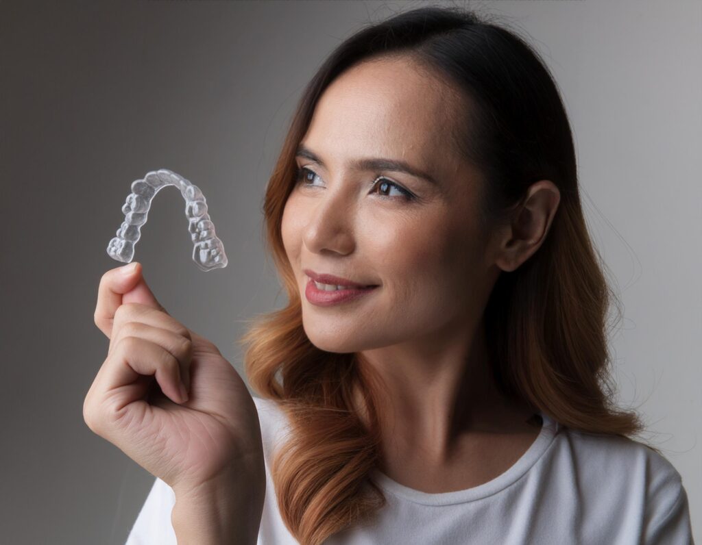 Invisalign aligners in hand