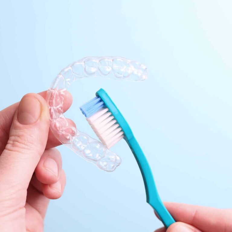 Cleaning plastic aligner aligners with a toothbrush . High quality photo